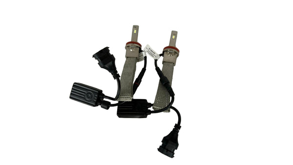 Car headlight bulbs with wiring on a white textured surface