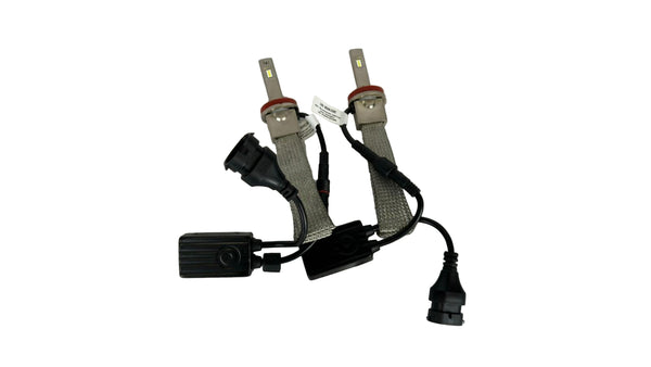 Two car light bulbs with connectors on a white fabric background