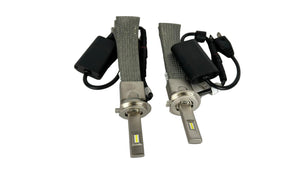 Two car headlight bulbs with connectors on a white background