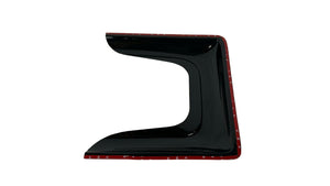 Black car spoiler with red trim on a white quilted surface