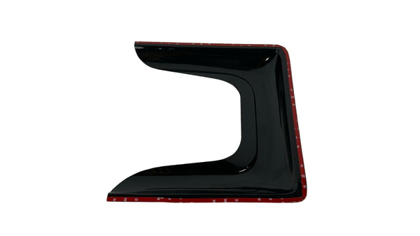 Black car spoiler with red trim on a white quilted surface